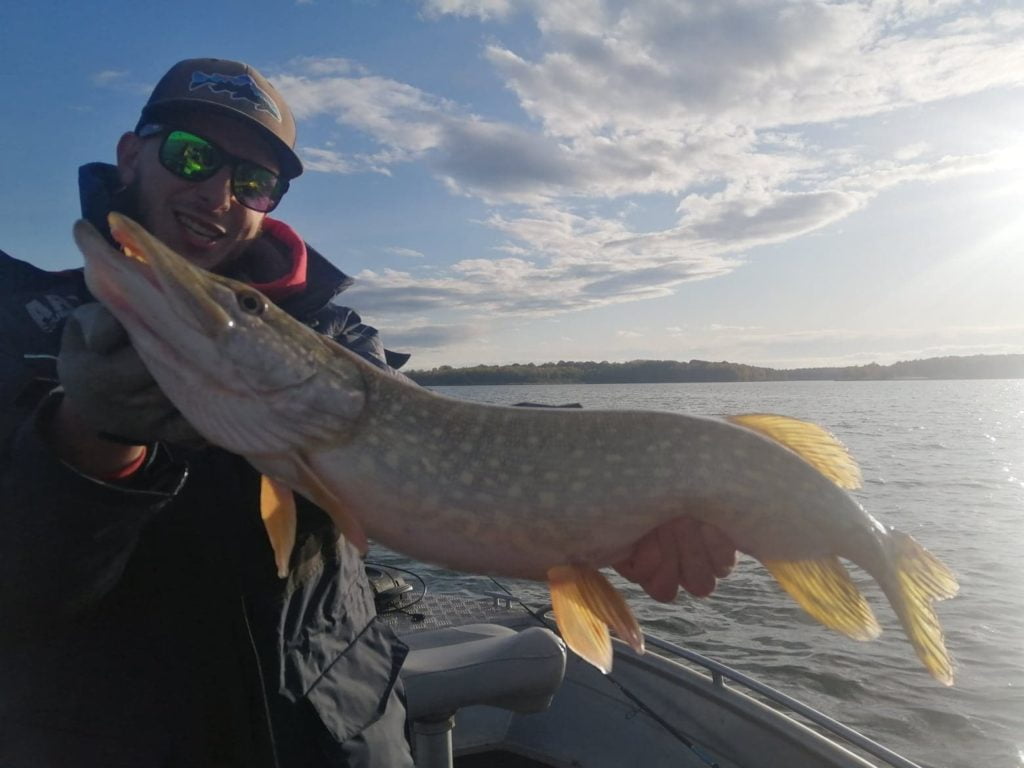 Le guide de pêche avec un brochet sur les lacs d'Orient