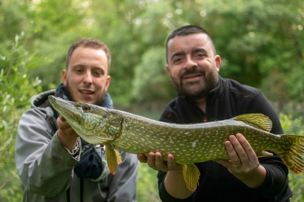 Un client heureux avec son guide de peche apres la capture d'un brochet lors d'une guidage carnassiers dans l'Aube